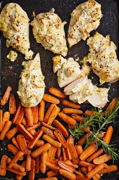 chicken, carrots and potatoes on a baking sheet with seasoning sprinkled