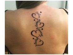 the back of a woman's neck with two hearts and words tattooed on it