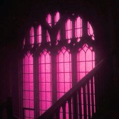 the stairs are lit up with bright pink lights in front of large stained glass windows