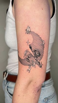 a woman's arm with a black and white tattoo design on the left shoulder