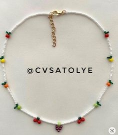 a white beaded bracelet with colorful beads and charms on the clasp, which reads cvastolyee