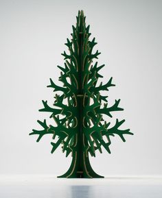 a green wooden christmas tree on a white surface