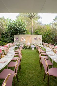 a long table set up with pink chairs