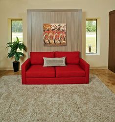 a living room with a red couch and rug