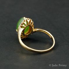 Ideal for punctuating your daily look with an eye-catching and energetically welcoming piece, this Teardrop Nephrite Jade Ring is both classic and modern. The teardrop cut center stone is a natural, untreated AAA nephrite jade of 4.15 carats and is set in a prong setting and surrounded by a diamond halo with 0.10 carats of sparkling white diamonds. The unique 18kt rose gold band is simple yet contemporary in style, bringing the best of all aesthetics into one design. Dimensions: Center Stone: Na Classic Green Teardrop Emerald Ring, Green Oval Opal Ring With Bezel Setting, Elegant Green Opal Oval Ring, Formal Green Teardrop Ring, Modern Oval Jade Ring, Elegant Green Opal Ring With Oval Cabochon, Green Teardrop Fine Jewelry Ring, Elegant Green Opal Ring Oval Cabochon, Jade Teardrop Pendant Gemstone Jewelry