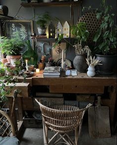 a table with some plants on top of it and a chair in front of it