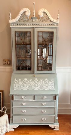 an old dresser with glass doors and ornate carvings