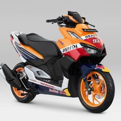 an orange, white and blue motorcycle is shown in front of a gray background with the words repsol on it