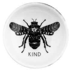 a white plate with a black and white bee on it's side that says kind