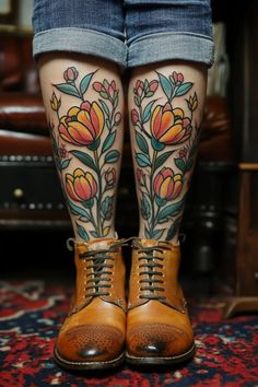 the legs and ankles of a woman with flowers tattooed on her leg, wearing brown boots