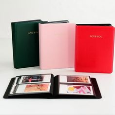 four different colored binders sitting next to each other on top of a white table