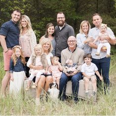 an image of a family posing for a photo in front of some trees and grass