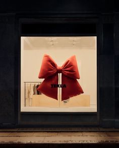 a store window with a red bow on the front