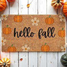 a door mat that says hello fall with pumpkins around it