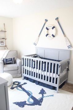 a baby's room is decorated in blue and white with an anchor rug on the floor