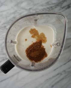 a blender filled with brown and white ingredients