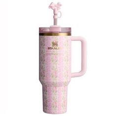 a pink coffee cup with a handle and flower pattern on it, sitting next to a white background