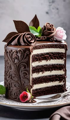 a slice of chocolate cake with white frosting and flowers on the top, sitting on a plate