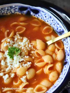 a bowl of pasta soup with cheese and parmesan on the top, ready to be eaten