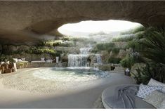 an outdoor pool with waterfall and lounge chairs next to it, surrounded by greenery