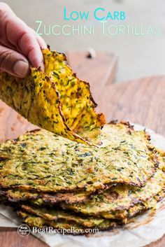 a person dipping a tortilla chip into some sort of food on a plate