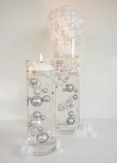 two clear vases with silver balls and candles