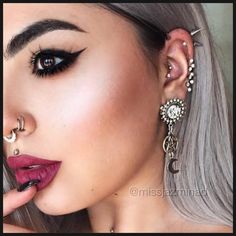 a woman with grey hair and piercings on her ear