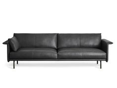 a black leather couch sitting on top of a white floor