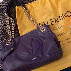 Valentino Handbag. Gold Chain With Leather Handles. Two Pockets In Front Under Emblem. Super Soft Purple Leather. My Favorite. This Is A Medium Size Bag. Excellent Condition. Gb1 Luxury Purple Bag With Branded Hardware, Designer Bag With Chain Strap, Designer Shopping Bag With Chain Strap, Designer Bags With Chain Strap For Shopping, Purple Leather Shoulder Bag With Chain Strap, Chic Purple Bags With Branded Hardware, Luxury Purple Shoulder Bag With Chain Strap, Valentino Handbags, Soft Purple