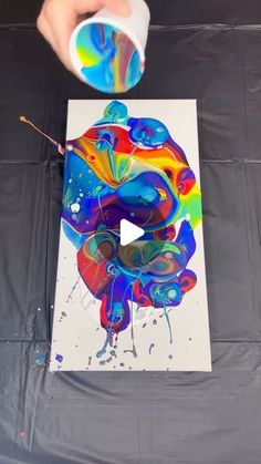 a person is painting on a canvas with acrylic paint