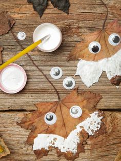 the leaves have been painted with googly eyes and are sitting next to some paint