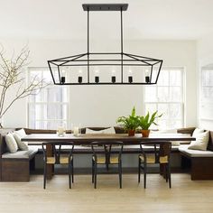 the dining room table is surrounded by benches and chairs, along with potted plants