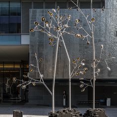 a tall metal tree sitting in front of a building