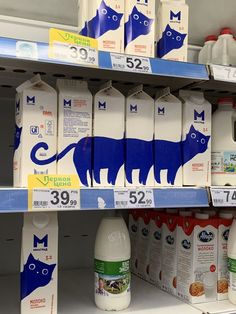 milk cartons are stacked on the shelves in a grocery store with cats painted on them