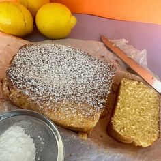 a piece of cake sitting on top of a table next to some lemons and a knife