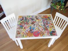 a table and two chairs are covered with colorful stickers on the top, along with a wall behind it