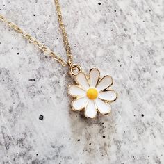 Step into a world of playful elegance with this Gold Dainty Daisy Charm Necklace. This adorable piece of jewelry is here to add a touch of enchantment to your everyday style. It's like capturing a piece of nature's cheerfulness and wearing it as a symbol of your vibrant spirit. This necklace brings a lighthearted touch to any outfit, whether you're dressing up for a special occasion or adding a playful accent to your casual look. Its dainty design and shimmering gold finish effortlessly elevate Enamel Necklaces With Flower Charm And Pendant, Enamel Flower Pendant Necklace With Charm, Enamel Flower Pendant Necklace With Flower Charm, Yellow Enamel Round Jewelry, Whimsical Clavicle Chain Necklaces For Gifts, Whimsical Clavicle Chain Necklace For Gift, Delicate Adjustable Necklace With Flower Charm, Delicate Flower Charm Necklace For Her, Delicate Flower Charm Necklace Gift For Her