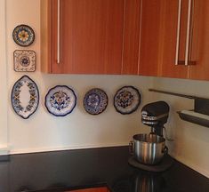 a coffee pot sitting on top of a stove next to a mixer and some plates