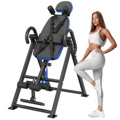 a woman standing next to an exercise machine with the seat up and back on it