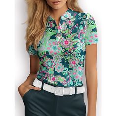 a woman wearing a green floral shirt and black pants with her hands on her hips