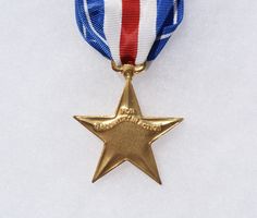 a gold medal with a red, white and blue ribbon around it's neck