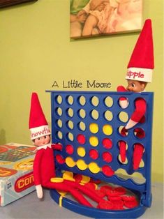 two elfs are playing with a game on the table next to an apple box