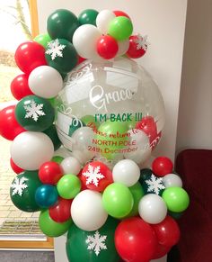 a balloon arch with snowflakes and balloons attached to it in front of a window