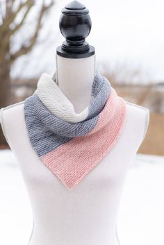 a white mannequin with a pink and grey scarf on it's neck