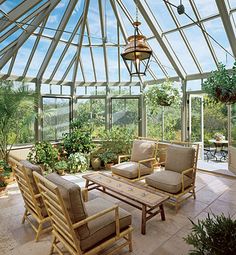 a sun room filled with lots of plants and furniture