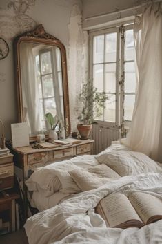 an unmade bed sitting in front of a window next to a dresser and mirror