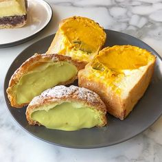 three pieces of bread with different toppings on a plate next to another piece of cake