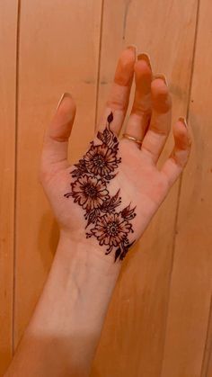 a woman's hand with a henna tattoo on her left arm and wrist