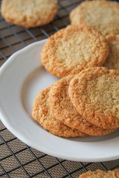 some cookies are on a white plate with a cooling rack in the backgroud