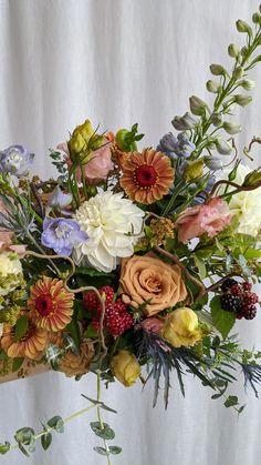 a vase filled with lots of different colored flowers